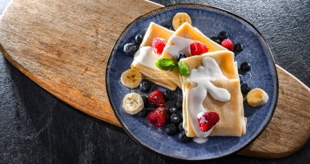 Téléchargez les photos : Une assiette de crêpes polonaises maison remplie de fromage cottage sucré - en image libre de droit
