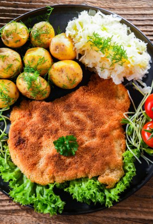 Téléchargez les photos : Pork breaded cutlet coated with breadcrumbs served with potatoes and cabbage - en image libre de droit