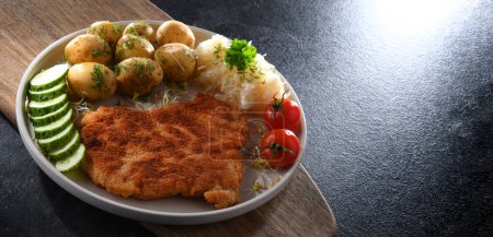 Photo for Pork breaded cutlet coated with breadcrumbs served with potatoes and cabbage - Royalty Free Image
