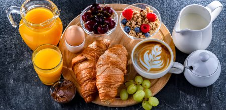 Frühstück mit Kaffee, Orangensaft, Ei, Müsli und Croissants.