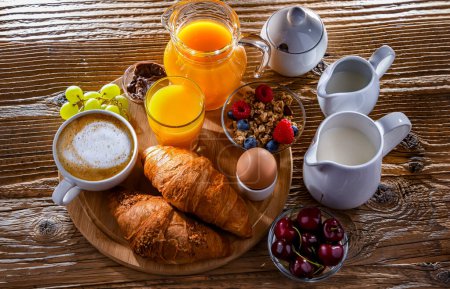 Téléchargez les photos : Petit déjeuner servi avec café, jus d'orange, oeuf, céréales et croissants. - en image libre de droit
