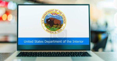 Foto de POZNAN, POL - DEC 5, 2023: Computadora portátil que muestra el sello del Departamento del Interior de los Estados Unidos, un departamento ejecutivo del gobierno federal de los Estados Unidos - Imagen libre de derechos