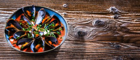 Photo for A plate of mussels in tomato sauce served with parsley and lemon - Royalty Free Image