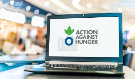 Foto de POZNAN, POL - DIC 5, 2023: Computadora portátil que muestra el logotipo de Action Against Hunger, una organización humanitaria mundial comprometida a acabar con el hambre en el mundo - Imagen libre de derechos