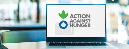 Téléchargez les photos : POZNAN, POL - DEC 5, 2023 : Ordinateur portable affichant le logo d'Action contre la faim, une organisation humanitaire mondiale engagée pour mettre fin à la faim dans le monde - en image libre de droit