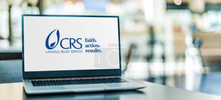 Photo for POZNAN, POL - DEC 5, 2023: Laptop computer displaying logo of Catholic Relief Services, the international humanitarian agency of the Catholic community in the USA - Royalty Free Image