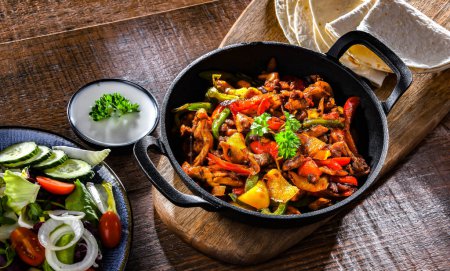 Photo for Fajita with stripped peppers and onions served on a hot iron skillet - Royalty Free Image