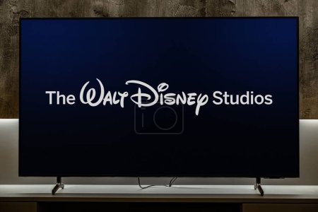 Téléchargez les photos : POZNAN, POL - DEC 19, 2023 : Téléviseur à écran plat affichant le logo de The Walt Disney Studios, une division majeure du segment d'activité Disney Entertainment de The Walt Disney Company - en image libre de droit