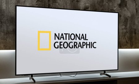 Téléchargez les photos : POZNAN, POL - DEC 19, 2023 : Téléviseur à écran plat affichant le logo de National Geographic, un réseau américain de télévision payante et chaîne phare, détenu par National Geographic Partners - en image libre de droit