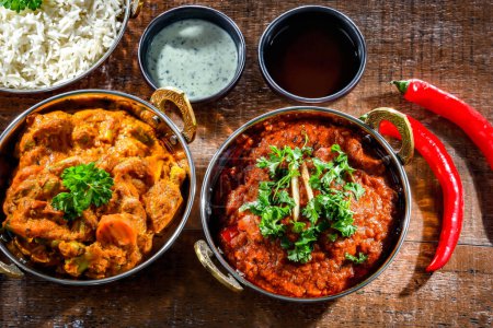Foto de Hot madras paneer and vegetable masala with basmati rice served in original indian karahi pots. - Imagen libre de derechos