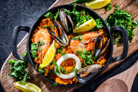Téléchargez les photos : Seafood paella served in a cast iron pan. - en image libre de droit