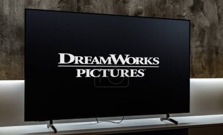Foto de POZNAN, POL - DIC 19, 2023: Televisor de pantalla plana con el logotipo de DreamWorks Pictures, una productora cinematográfica estadounidense, y una etiqueta de Amblin Partners - Imagen libre de derechos