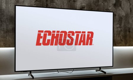 Foto de POZNAN, POL - DIC 19, 2023: Televisor de pantalla plana que muestra el logotipo de EchoStar Corporation, una empresa estadounidense, un proveedor mundial de servicios de comunicación por satélite e Internet - Imagen libre de derechos