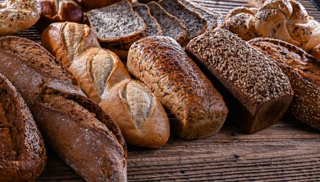 Photo for Assorted bakery products including loaves of bread and rolls. - Royalty Free Image