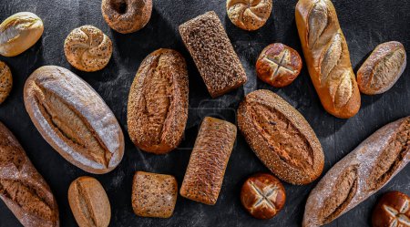 Foto de Assorted bakery products including loaves of bread and rolls. - Imagen libre de derechos