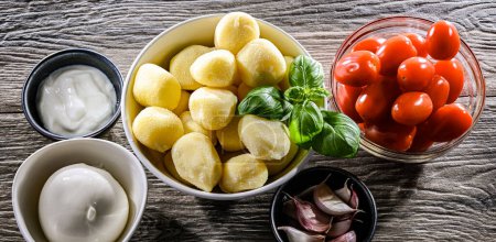 Photo for Ingredients of the recipe for creamy tomato gnocchi with burrata, basil and garlic. - Royalty Free Image