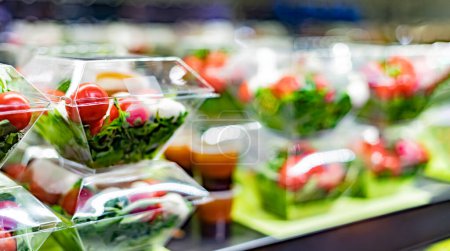 Foto de Ensaladas de verduras preenvasadas exhibidas en un refrigerador comercial - Imagen libre de derechos