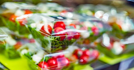 Foto de Ensaladas de verduras preenvasadas exhibidas en un refrigerador comercial - Imagen libre de derechos