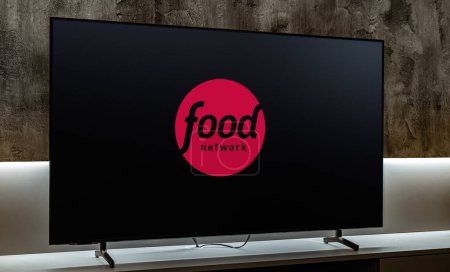 Foto de POZNAN, POL - 01 MAR 2024: Televisor de pantalla plana con el logotipo de Food Network, un canal de cable básico estadounidense propiedad de Television Food Network, G.P. - Imagen libre de derechos