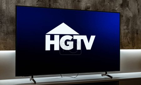 Téléchargez les photos : POZNAN, POL - MAR 01, 2024 : Téléviseur à écran plat affichant le logo de HGTV (Home & Garden Television), une chaîne de télévision payante américaine détenue par Discovery, Inc. - en image libre de droit