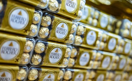 Foto de DUBAI, Emiratos Árabes Unidos - 06 MAR 2024: Cajas de dulces de chocolate premium Ferrero Rocher puestas a la venta en la tienda del Aeropuerto Internacional de Dubái - Imagen libre de derechos