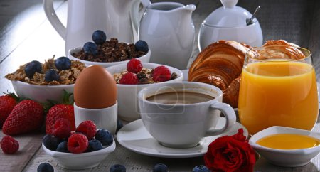Téléchargez les photos : Petit déjeuner servi avec café, jus d'orange, croissants, œufs, céréales et fruits. Régime alimentaire équilibré. - en image libre de droit