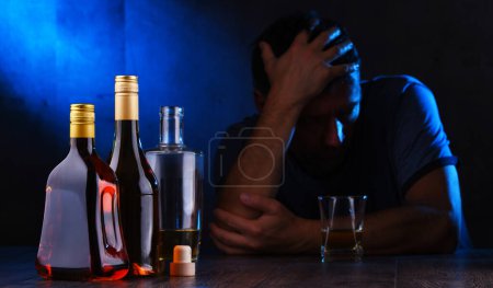 Téléchargez les photos : Bouteilles avec des boissons alcoolisées et la figure d'un homme ivre - en image libre de droit