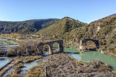Photo for Roncalese bridge, Medieval construction, with seven arches, semi ruined, located over the Aragn river near the town of Yesa, next to the fish farm. It has been part of the Camino de Santiago - Royalty Free Image