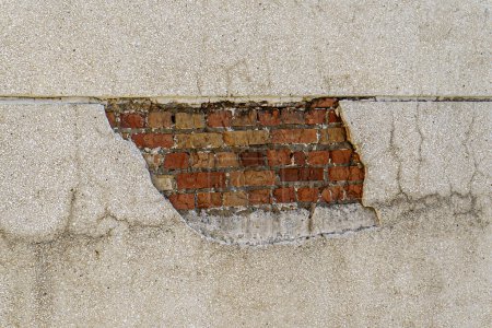 Téléchargez les photos : Mur plâtré avec des dommages dans lesquels les briques sont visibles. - en image libre de droit