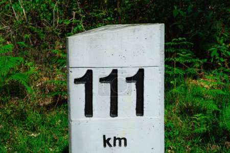 Foto de Marcador de hormigón vial con una distancia de 111 km. - Imagen libre de derechos