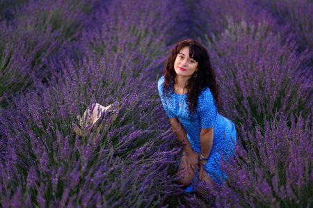 Photo for Portrait of a happy woman in a blue dress enjoying a sunny summer day in a lavender field. Fresh air, Lifestyle. - Royalty Free Image