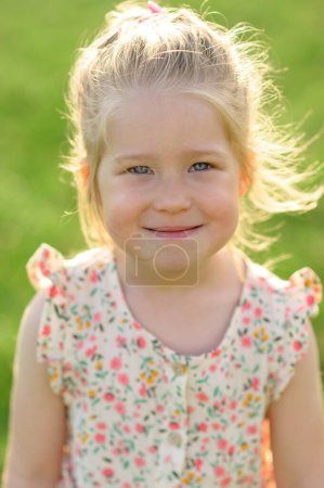 Photo for Little girl 3 years old in a summer sundress in the park. Summer time.the baby is looking into the frame. - Royalty Free Image