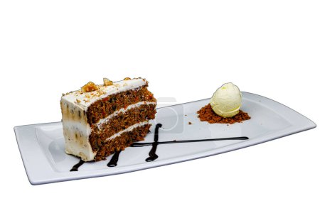 Foto de Composición de un pastel de zanahoria en un plato blanco con helado sobre un fondo blanco - Imagen libre de derechos