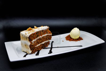 Photo for Composition of a Carrot cake on a white plate with ice cream on a black background - Royalty Free Image