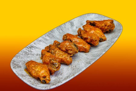 Téléchargez les photos : Composition d'un plat d'ailes de poulet avec sauce Buffalo sur fond rouge et jaune - en image libre de droit