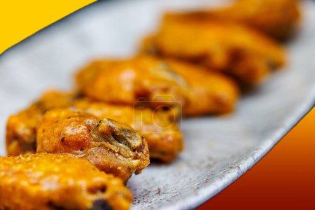 Photo for Composition of a dish of chicken wings with Buffalo sauce on a red and yellow background - Royalty Free Image