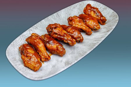 Téléchargez les photos : Composition d'une assiette d'ailes de poulet avec sauce barbecue sur fond de magenta et de dégradé bleu clair - en image libre de droit