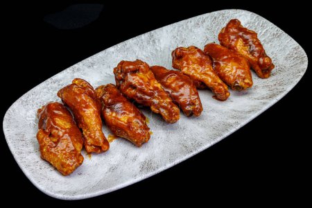 Photo for Composition of a plate of chicken wings with barbecue sauce on black background - Royalty Free Image