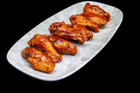 Photo for Composition of a plate of chicken wings with barbecue sauce on black background - Royalty Free Image