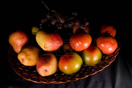 Téléchargez les photos : Composition des poires, tomates et raisins dans un panier - en image libre de droit