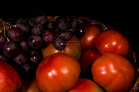 Téléchargez les photos : Composition des poires, tomates et raisins dans un panier - en image libre de droit