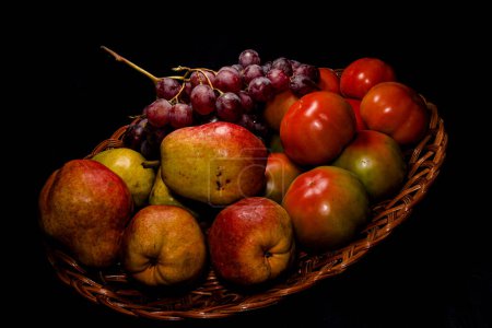 Photo for Composition of pears, tomatoes and grapes in a basket - Royalty Free Image