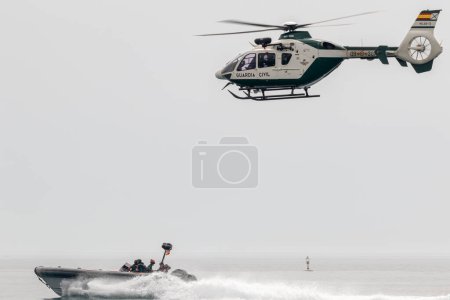 Photo for TORRE DEL MAR, MALAGA, SPAIN-JUL 12: Guardia Civil coast guard patrol and helicopter EC-135 taking part in a exhibition on the 4th airshow of Torre del Mar on July 12, 2019, in Torre del Mar, Malaga, Spain - Royalty Free Image