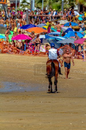 Foto de SANLUCAR DE BARRAMEDA, CADIZ, ESPAÑA - 12 AGO: Jinete no identificado al inicio de la primera carrera de caballos llamada Premio Honda Autovin el 12 de agosto de 2016 en Sanlúcar de Barrameda, Cádiz, España
. - Imagen libre de derechos
