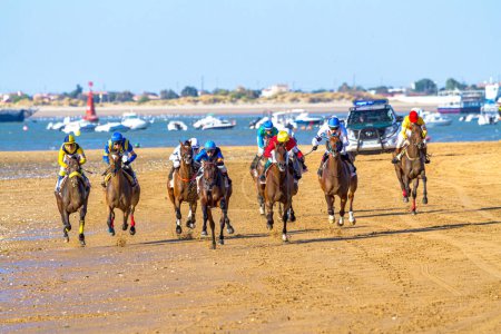 Foto de SANLUCAR DE BARRAMEDA, CADIZ, ESPAÑA - 7 AGO: Jinetes no identificados corren la segunda carrera de caballos llamada Longines Fegrentri el 7 de agosto de 2014 en Sanlúcar de Barrameda, Cádiz, España
. - Imagen libre de derechos