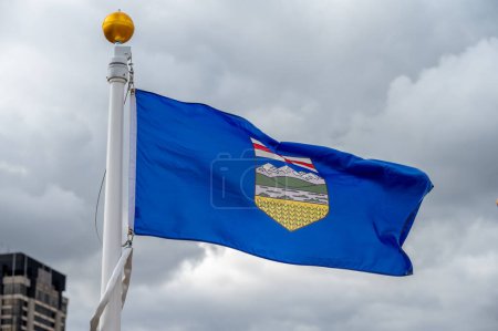 Flag of Alberta waiving on a cloudy Canadian day.
