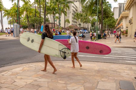 Foto de Honolulu, Hawaii - December 29, 2022: Family carrying  surfboards to Waikiki Beach. - Imagen libre de derechos