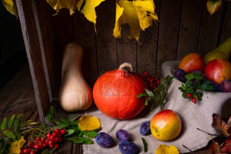 Foto de Varias frutas en una caja de madera con hojas de otoño - Imagen libre de derechos