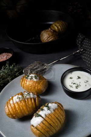 Photo for Hasselback potatoes with quark and herbs on the plate - Royalty Free Image