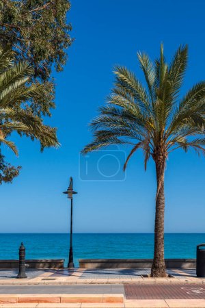 Foto de Composición minimalista con una linterna en el paseo marítimo. Un día soleado y cálido en un resort en España. - Imagen libre de derechos